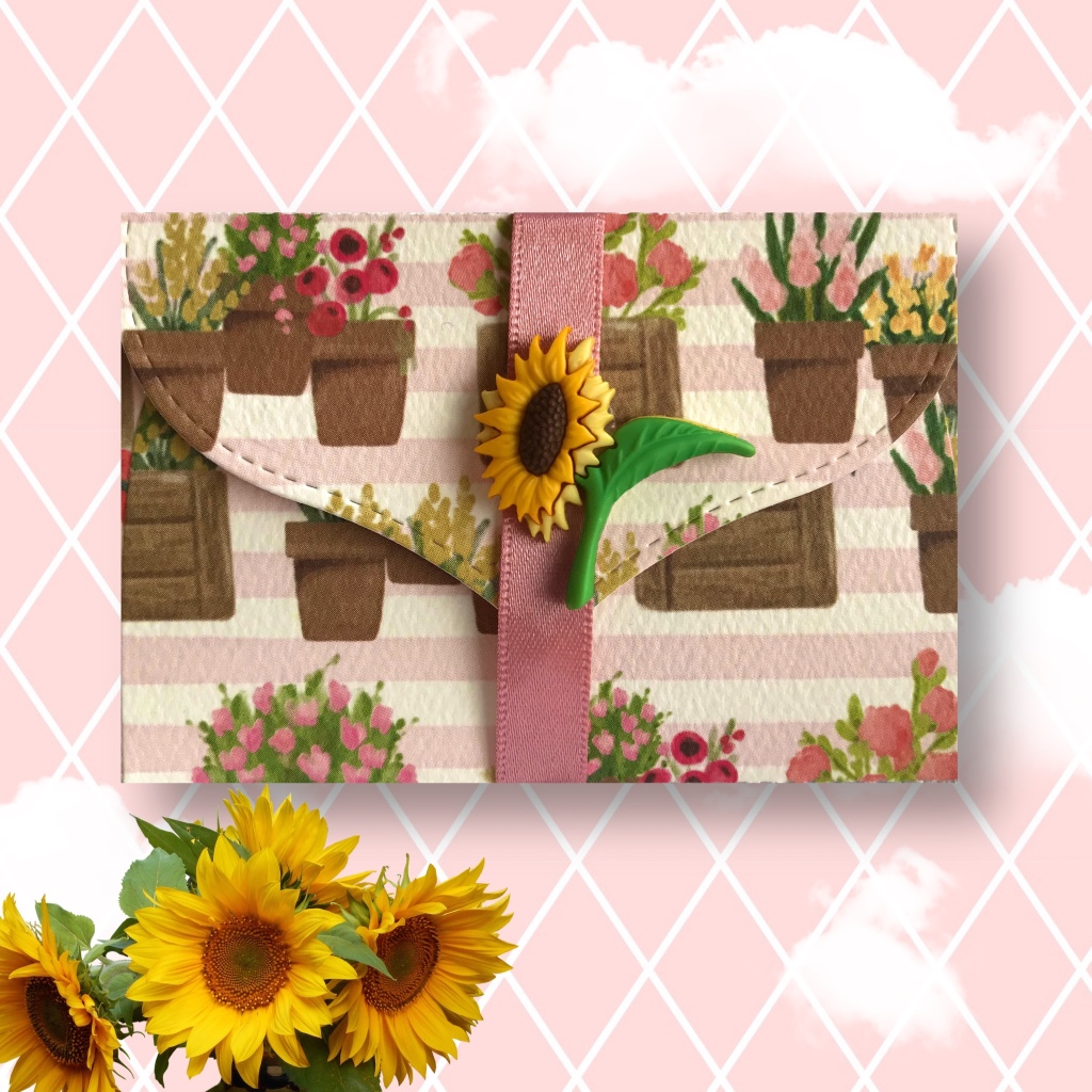 A small envelope with watercolour painted flowers in pots. A sunflower fastener on the front. Gift card holder envelope.